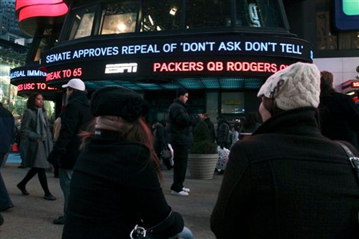 Cassandra Melnikow, foreground left, and her sister Victoria Melnikow,  right, sit in New York's Times Square as news of the Senate approving the repeal of "Don't Ask Don't Tell" is displayed outside ABC Television's Times Square studios Saturday Dec. 18, 2010. (AP Photo/Tina Fineberg) (AP)
