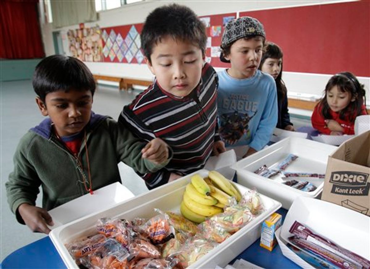 Fairmeadow Elementary School second grade student Jonathan Cheng, center, looks at fruits and vegetables during a school lunch program in Palo Alto, Calif., Thursday, Dec. 2, 2010. More children would eat lunches and dinners at school under legislation passed Thursday by the House and sent to the president, part of first lady Michelle Obama's campaign to end childhood hunger and fight childhood obesity. The $4.5 billion bill approved by the House 264-157 would expand a program that provides full meals after school to all 50 states. It would also try to cut down on greasy foods and extra calories by giving the government power to decide what kinds of foods may be sold in vending machines and lunch lines. (AP Photo/Paul Sakuma)  (AP)