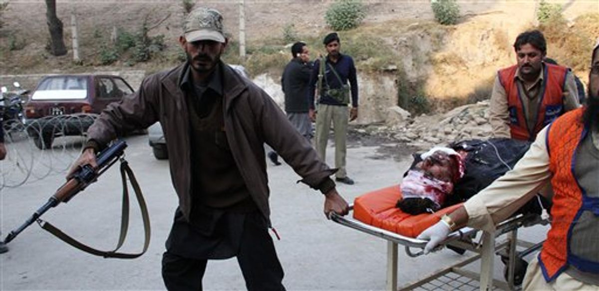 Pakistani volunteers rush a person injured by suicide attack to an emergency ward of a local hospital in Peshawar, Pakistan on Monday, Dec. 6, 2010. A pair of suicide bombers disguised as policemen killed many people in an attack targeting a tribal meeting called to discuss the formation of an anti-Taliban militia, in Pakistani tribal area of Mohmand. (AP Photo/Mohammad Iqbal) (AP)