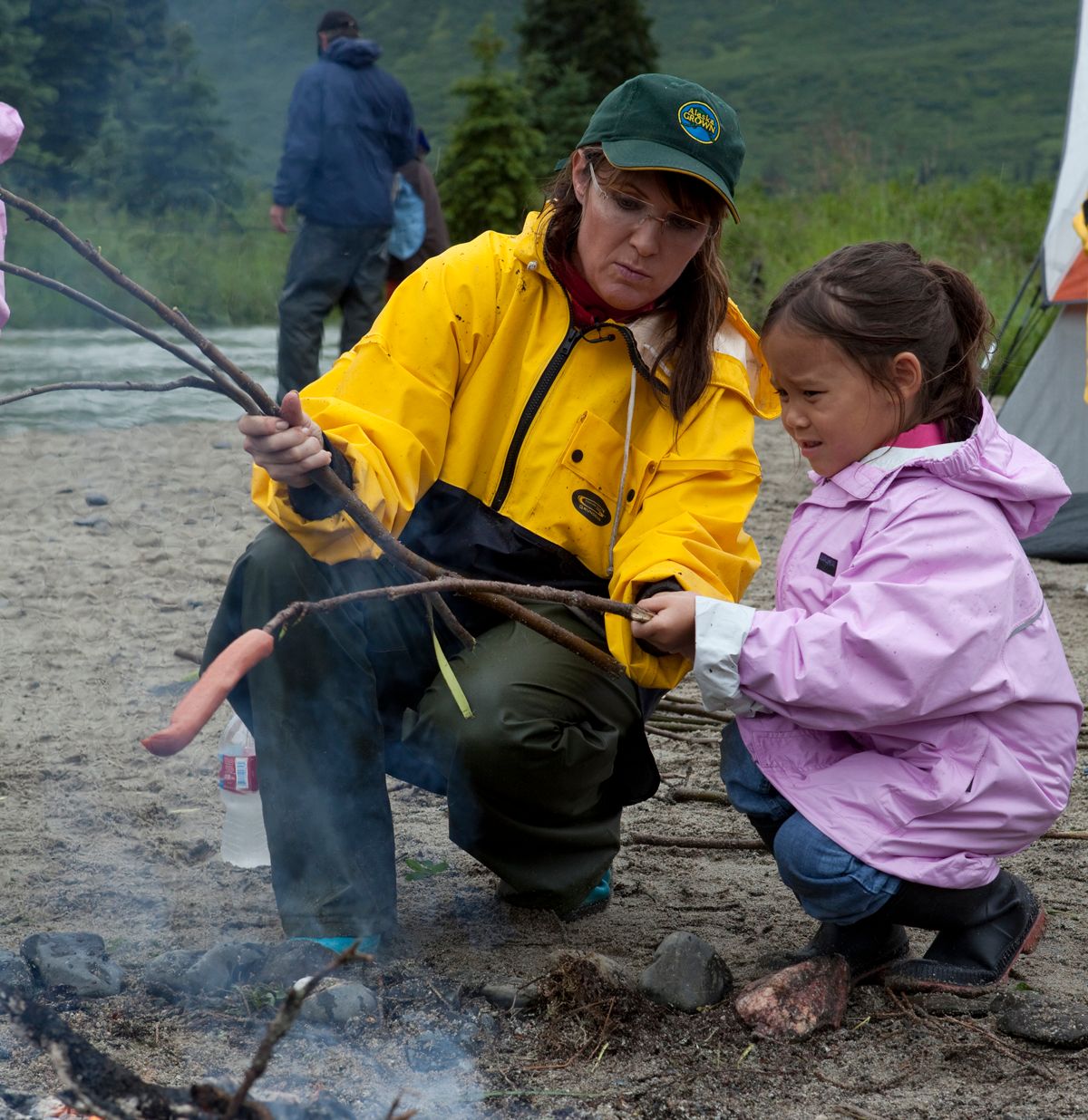 COFFEE CREEK, ALASKA, JUY 25 2010: Under a steady, pouring rain, Sarah Palin helps Gosselin kids make a smore at the remote camping spot where the Gosselins were supposed to camp with the Palins, but cancelled and left for a lodge because of the rain (photo Gilles Mingasson/Getty Images)  (Gilles Mingasson/getty Images)