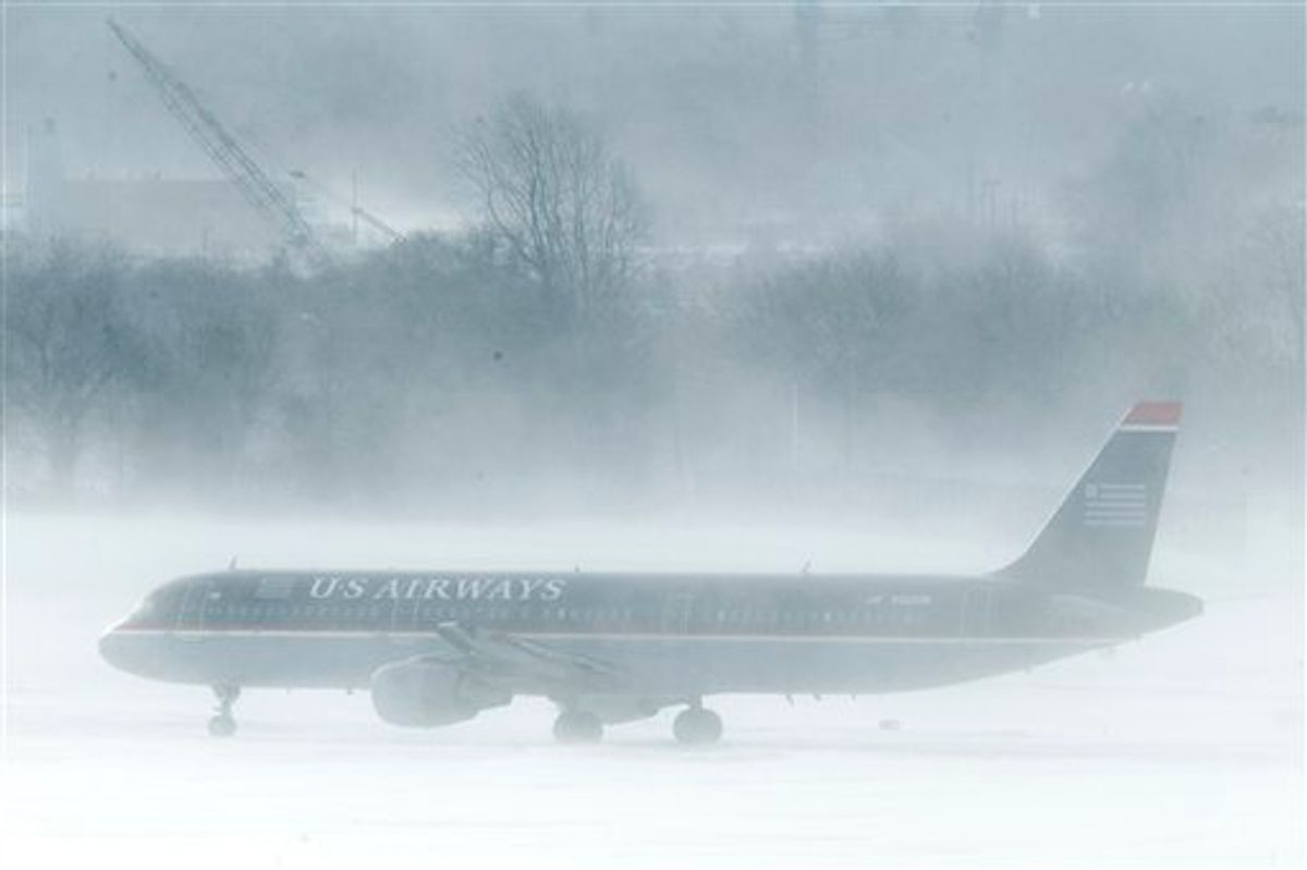 A U.S. Airways jet is seen amidst snow blown by gust of wind at the Philadelphia International Airport  in Philadelphia, Monday, Dec. 27, 2010. A powerful East Coast blizzard menaced would-be travelers by air, rail and highway Monday, leaving thousands without a way to get home after the holidays and shutting down major airports and rail lines for a second day. (AP Photo/Matt Rourke)  (Matt Rourke)