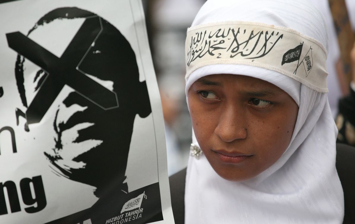 A Muslim woman displays a poster of defaced U.S. President Barack Obama during a protest against his planned visit outside the U.S. Embassy in Jakarta, Indonesia, Sunday, Nov. 7, 2010. Obama is scheduled to visit the world's most populous Muslim nation next week. (AP Photo/Dita Alangkara) (AP)