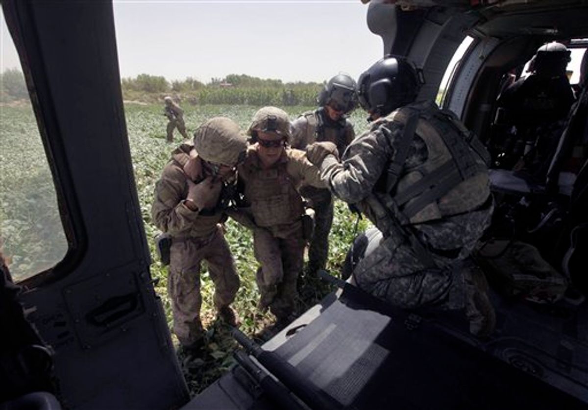 In this Sept. 2, 2010 photo, a U.S. Marine, left, Flight Medic Staff Sgt. Richard Jarrett, second from right, and Crew Chief Spc. Bryan Channon, of Okla., help U.S. Marine Pfc. Justin Turner, center, of Flower Mound, Texas, who was wounded in an IED attack, aboard a U.S. Army Task Force Shadow medevac helicopter, west of Lashkar Gah, in southern Afghanistan. Aeromedical teams with the 101st Airborne's Task Force Destiny provide the fast medical evacuation of those wounded throughout southern Afghanistan. (AP Photo/Brennan Linsley) (AP)