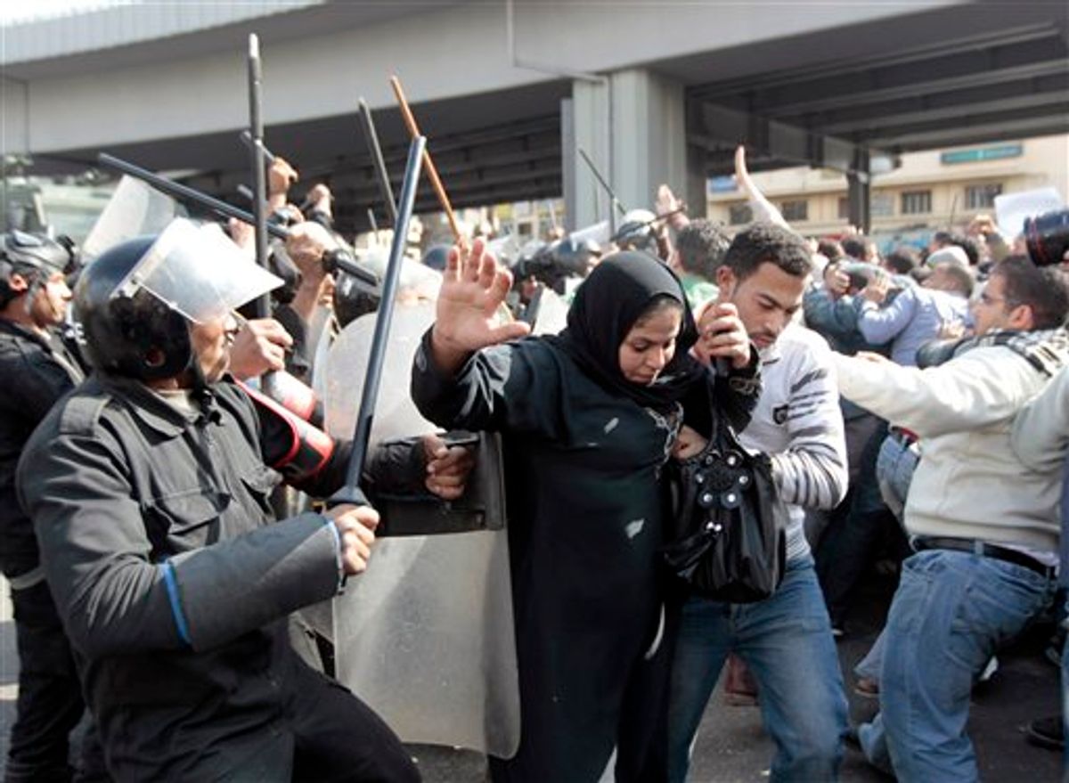 An Egyptian woman flees as Egyptian anti-riot policemen clash with protesters in Cairo, Egypt, Friday, Jan. 28, 2011. Egyptian activists protested for a fourth day as social networking sites called for a mass rally in the capital Cairo after Friday prayers, keeping up the momentum of the country's largest anti-government protests in years. (AP Photo/Lefteris Pitarakis) (AP)