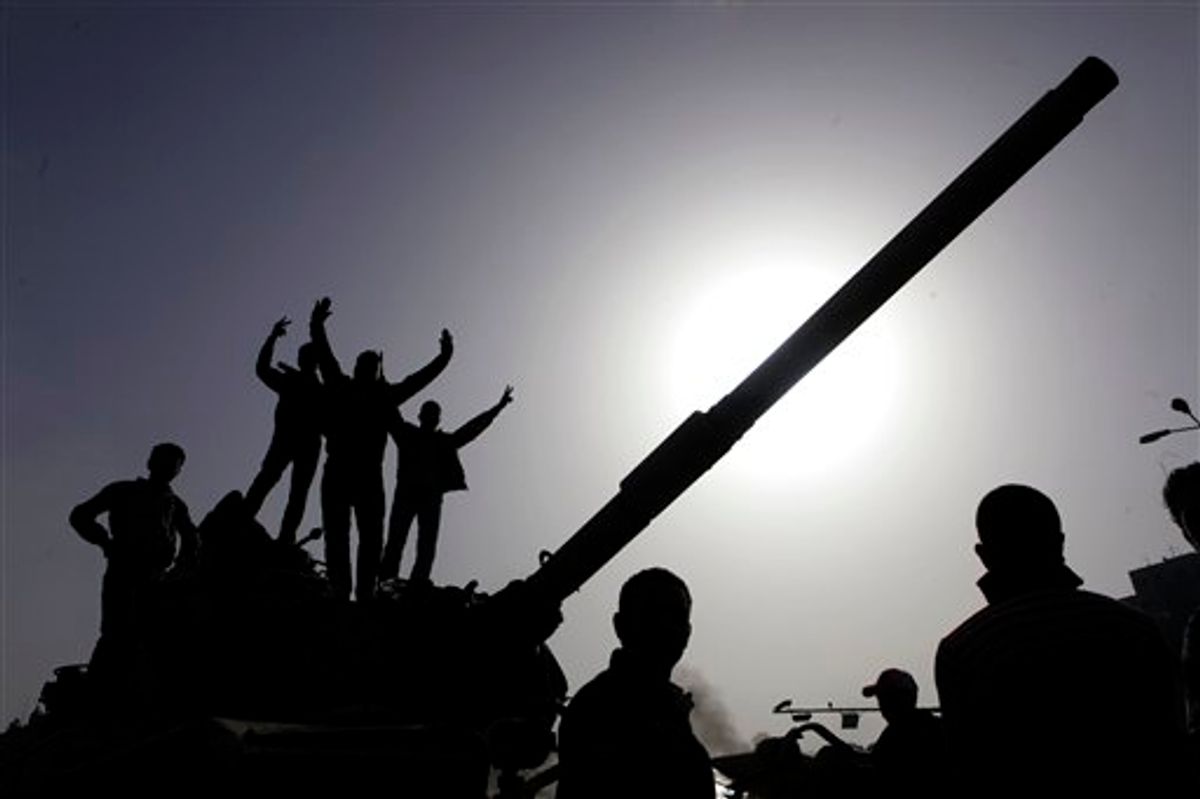Egyptians gesture as they stand atop an Egyptian army armored vehicle as they celebrate in downtown Cairo, Egypt, Saturday, Jan. 29, 2011. Hundreds of anti-government protesters returned Saturday to the streets of central Cairo, chanting slogans against Hosni Mubarak and attacking police just hours after the Egyptian president fired his Cabinet and promised reforms but refused to step down. (AP Photo/Amr Nabil) (AP)