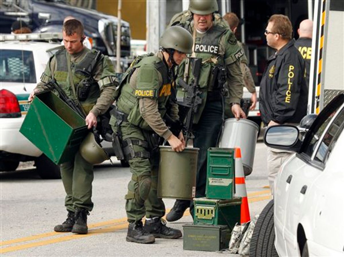 Swat team members stack their gear after the suspect in the shooting of three law enforcement officers was found dead Monday, Jan. 24, 2011 in south St. Petersburg, Fla.  Police say a gunman suspected of killing two Florida police officers and wounding a U.S. marshal during a shootout has been found dead. St. Petersburg Police spokesman Michael Puetz says the suspect was found dead when officers went into the home Monday afternoon, about six hours after the shootout. Puetz said officers originally went to the home to arrest 39-year-old Hydra Lacy Jr.  (AP Photo/Chris O'Meara) (AP)