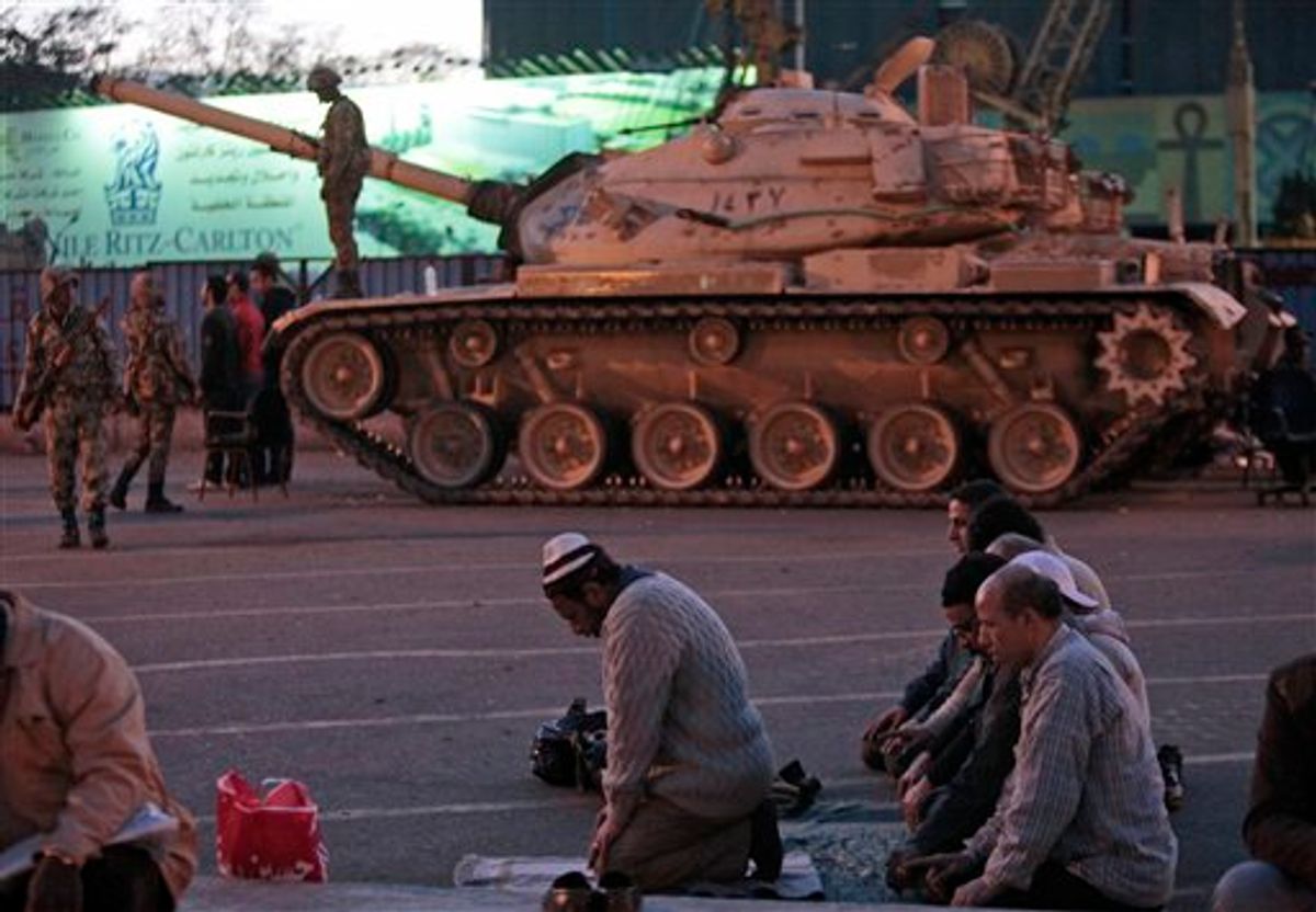 Anti-government protesters offer their evening prayers, in front of an Egyptian army tank securing the area, during a protest in Cairo's Tahrir Square, Egypt, Monday, Jan. 31, 2011. A coalition of opposition groups called for a million people to take to Cairo's streets Tuesday to demand the removal of Egyptian President Hosni Mubarak. (AP Photo/Lefteris Pitarakis) (AP)