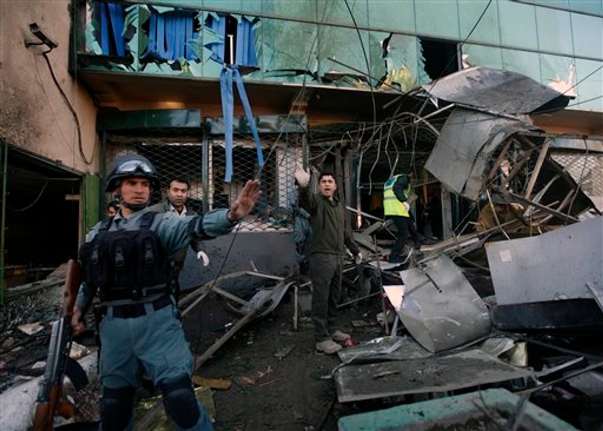 Afghan police men shout at photographers to prevent them approaching the entrance of damaged building of shopping complex after a suicide bomber detonated a cache of explosives inside the building in Kabul, Afghanistan, Monday, Feb, 14, 2011. An explosion rocked a shopping and hotel complex on Monday, killing at least two people, officials said, in the second attack in less than a month inside the heavily secured Afghan capital. (AP Photo/Dar Yasin) (AP)