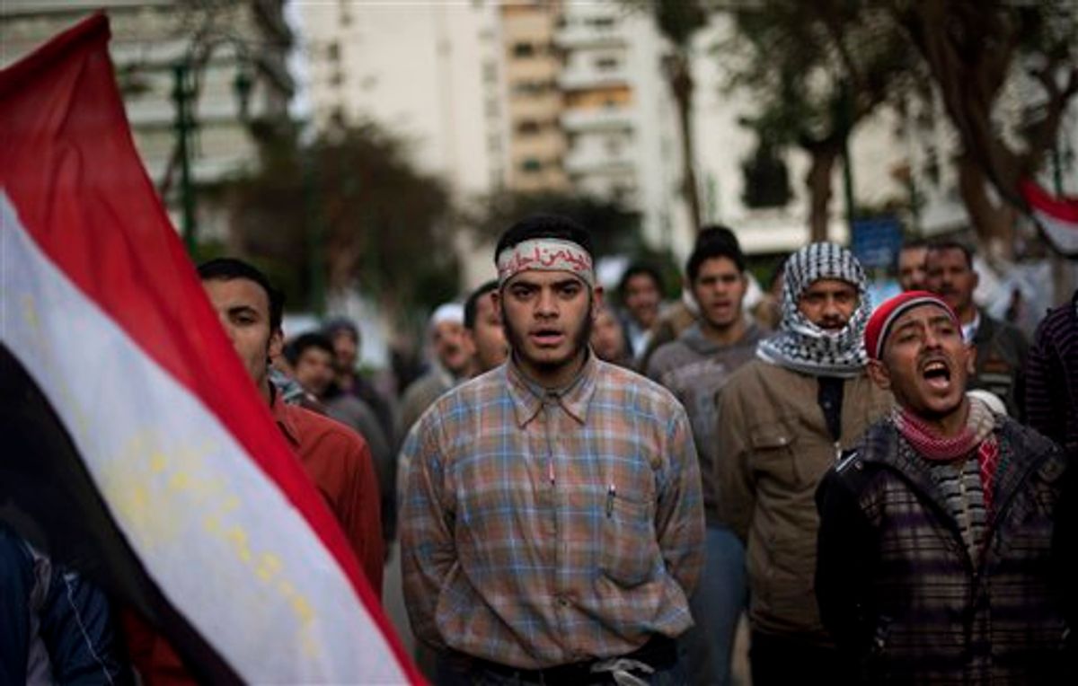 Anti-government protesters shout slogans as they line up after spending the night in front of the Egyptian Parliament in Cairo, Egypt, Thursday, Feb. 10, 2011. Around 2,000 protesters waved huge flags outside the parliament, several blocks from Tahrir Square, where they moved two days earlier in the movement's first expansion out of the square. (AP Photo/Emilio Morenatti) (AP)