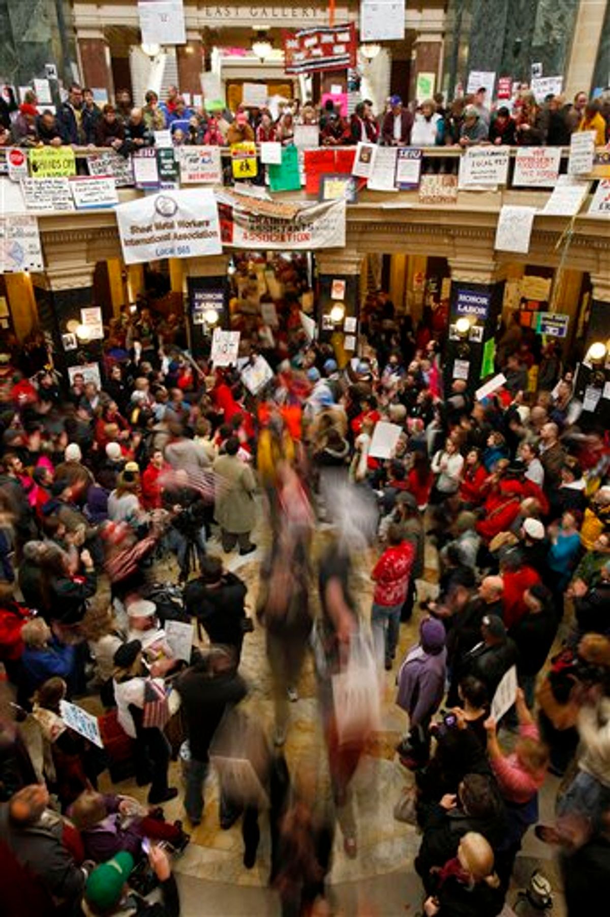 Protesters to the governor's bill to eliminate collective bargaining rights for many state workers march through the center of the rotunda at the state Capitol in Madison, Wis., Friday, Feb. 25, 2011.  Protests are in their 11th day at the Capitol. (AP Photo/Andy Manis) (AP)