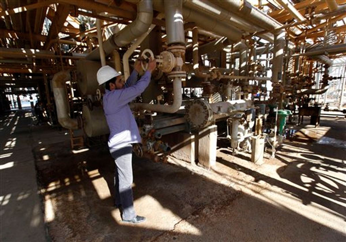 A Libyan oil worker, works at a refinery inside the Brega oil complex, in Brega east of Libya, on Saturday Feb. 26, 2011. Production at Brega has dropped by almost 90 percent amid the country's crisis because many employees have fled and few ships are coming to offload the product. (AP Photo/Hussein Malla) (AP)