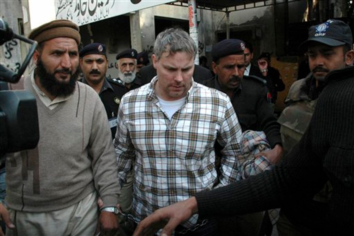 FILE - In this Jan. 28, 2011 file photo, Pakistani security officials escort Raymond A. Davis a U.S. consulate employee, center, to a local court in Lahore, Pakistan.  Most legal experts in Pakistan's government believe an American detained in the killing of two Pakistanis has diplomatic immunity, but a court should decide his fate, an official said Tuesday Feb. 15, 2011. The announcement reflected an apparent bid to open the way to the man's release while dampening public outrage. (AP Photo/Hamza Ahmed, File) (AP)