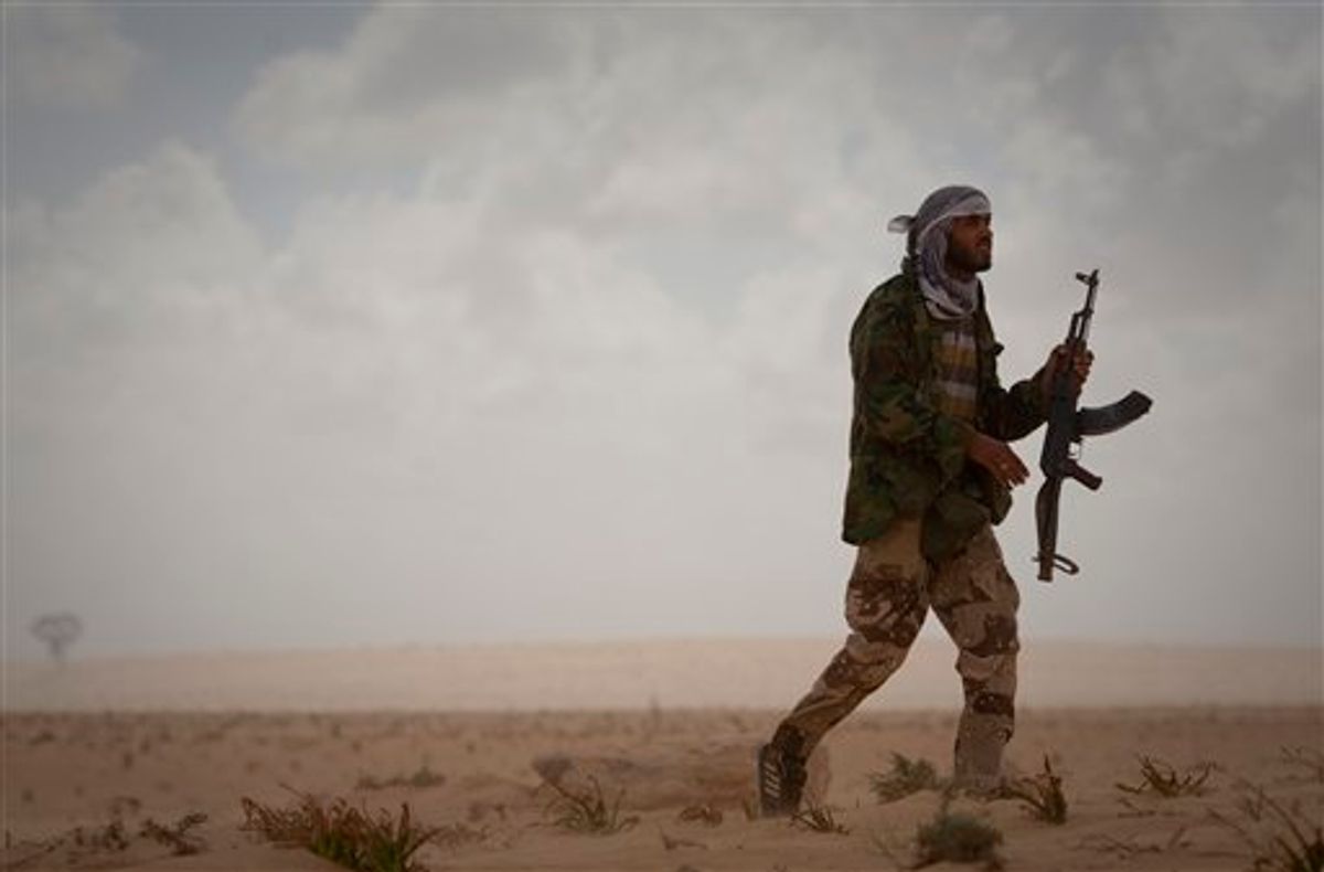 A Libyan rebel patrols the frontline of the outskirts of the city of Ajdabiya, south of Benghazi, eastern Libya, Monday, March 21, 2011. The international military intervention in Libya is likely to last "a while," a top French official said Monday, echoing Moammar Gadhafi's warning of a long war ahead as rebels, energized by the strikes on their opponents, said they were fighting to reclaim a city under siege from the Libyan leader's forces.(AP Photo/Anja Niedringhaus) (AP)