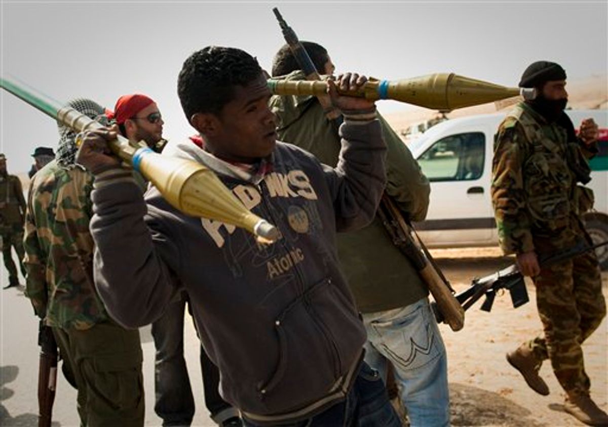 A Libyan rebels carries rockets on a checkpoint on the frontline near Zwitina, the outskirts of the city of Ajdabiya, south of Benghazi, eastern Libya, Thursday, March 24, 2011. (AP Photo/Anja Niedringhaus) (AP)