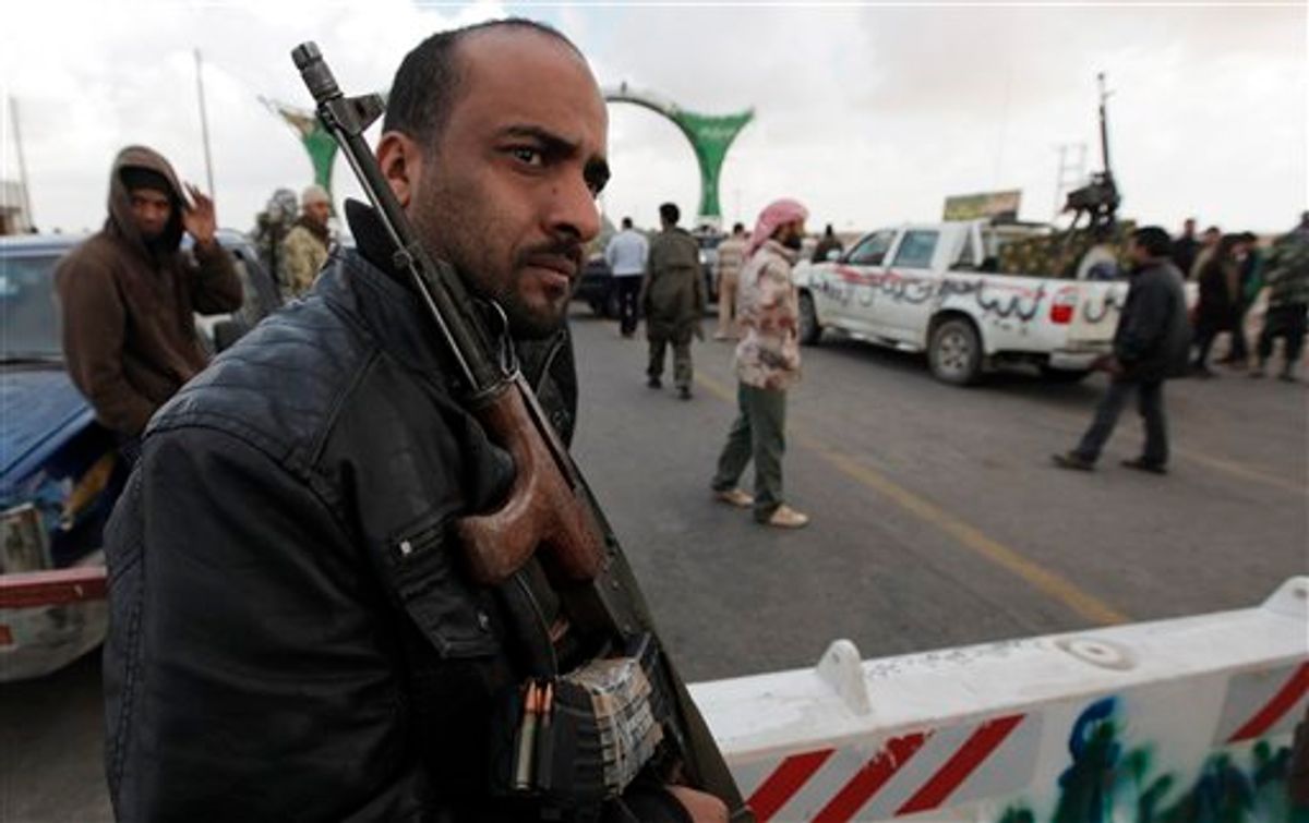 A Libyan rebel fighter guards the roadway to the western gate of Ajdabiya, Libya, Friday, April 1, 2011, as limited movement is being permitted across the frontier.  The western gate is closed Friday for journalists and civilians trying to reach the front line.  (AP Photo/Nasser Nasser) (AP)