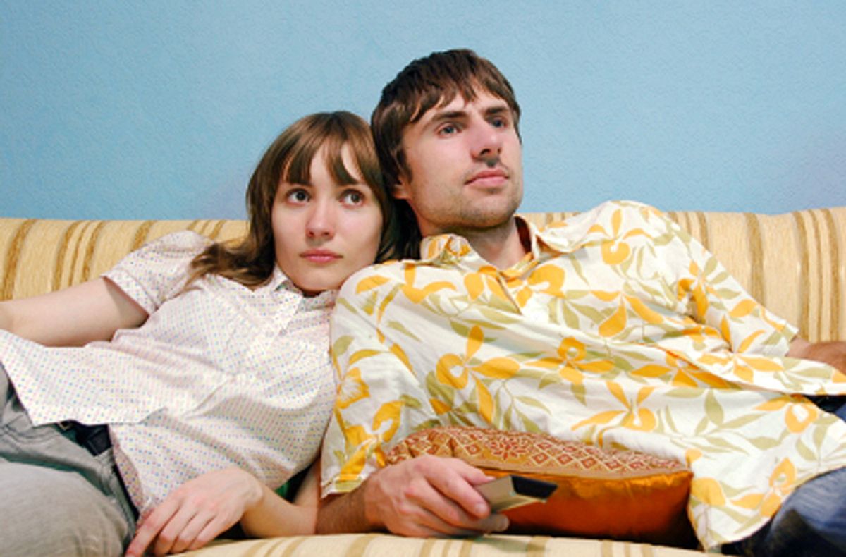 Young couple watching TV together on the couch