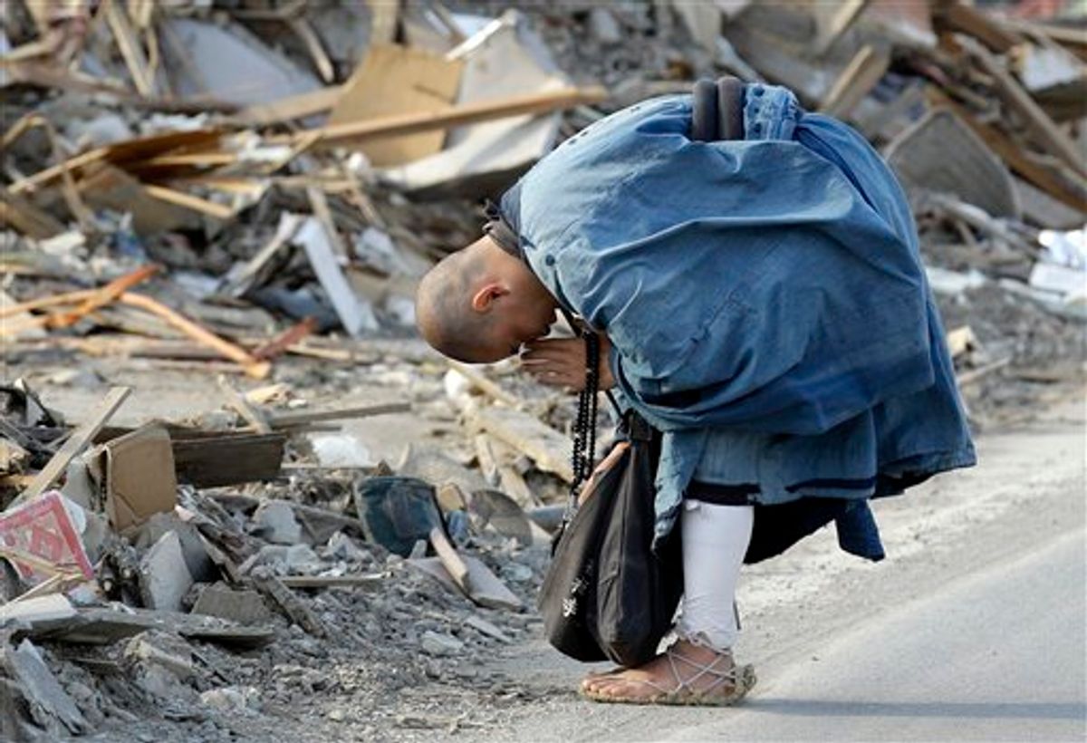 A Buddhist monk Sokan Obara, 28, from Morioka, Iwate Prefecture, prays for the victims in the debris in the area devastated by the March 11 tsunami in Ofunato, Iwate Prefecture, Japan, Thursday, April 7, 2011. (AP Photo/Lee Jin-man) (AP)