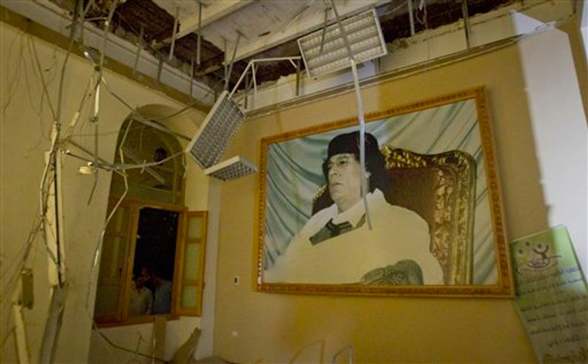 In this photo made on a government organized tour, a portrait of Moammar Gadhafi is seen inside damaged official building following an airstrike in Tripoli, Libya, early Saturday, April 30, 2011.(AP Photo/Darko Bandic) (AP)