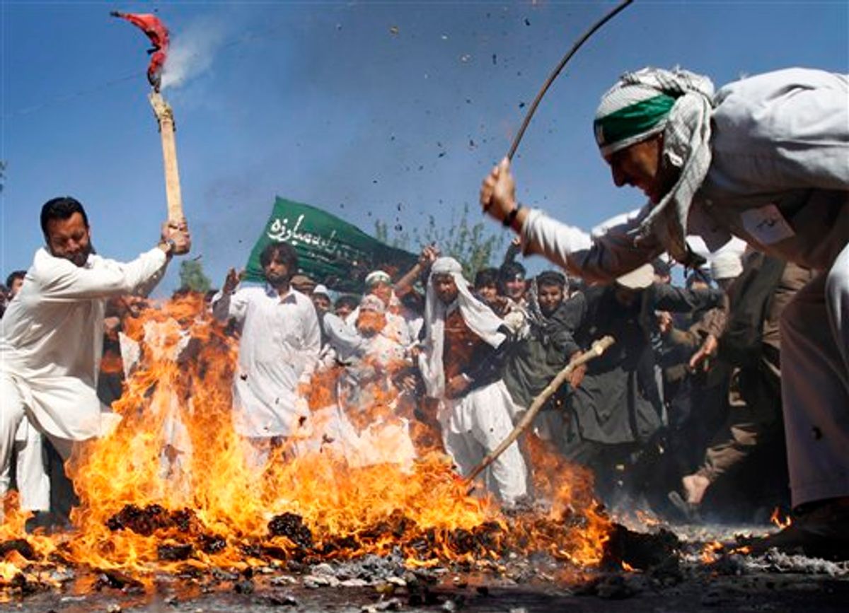 Afghan protestors beat a burning effigy of U.S. President Barack Obama during a demonstration in Jalalabad, Afghanistan on Sunday, April 3, 2011. Afghan protests against the burning of a Quran in Florida entered a third day with a demonstration in the major eastern city Sunday, while the Taliban called on people to rise up, blaming government forces for any violence. (AP Photo/Rahmat Gul) (AP)