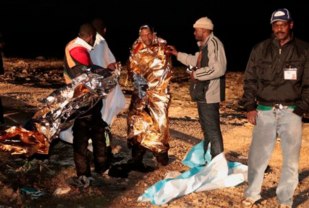 Migrants receives assistance as they arrive on the tiny island of Lampedusa, Italy, early Sunday, May 8, 2011. Italian police and coast guard officials on Sunday rescued some 400 illegal migrants coming from Libya whose boat was tossed against rocks near port in southern Italy after the steering malfunctioned, officials said. Tens of thousands of migrants have fled unrest in northern Africa since January, most arriving at Lampedusa, the nearest Italian port to Africa. (AP Photo/Francesco Malavolta) (AP)