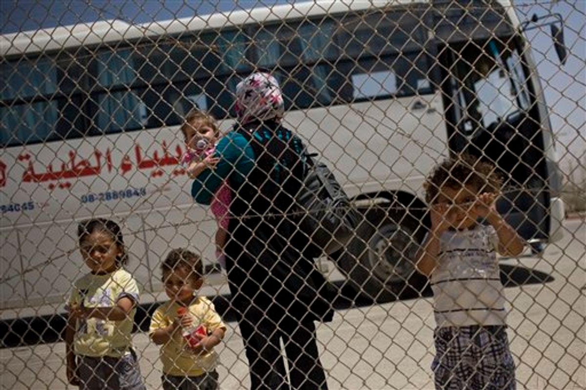 A Palestinian family waits before crossing into Egypt through the Rafah border crossing, southern Gaza Strip, Saturday, May 28, 2011. Egypt officially and fully reopens its passenger crossing with Gaza at the town of Rafah, after a long period of restrictions aimed at isolating the Hamas militant group that rules the Palestinian coastal strip which could ease the isolation of 1.4 million Palestinians there. (AP Photo/Bernat Armangue) (AP)