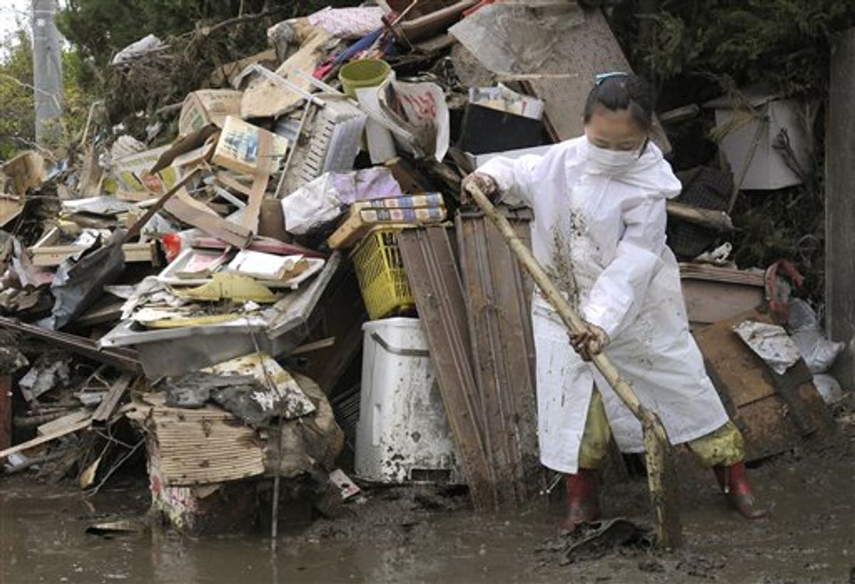 A volunteer girl from Tokyo works to clean the debris of a house in Higashimatsushima, northern Japan Saturday, April 30, 2011. She is a member of a Tokyo's volunteer group which helps earthquake and tsunami devastated areas on weekend. (AP Photo/Kyodo News) JAPAN OUT, MANDATORY CREDIT, NO LICENSING IN CHINA, HONG KONG, JAPAN, SOUTH KOREA AND FRANCE (AP)