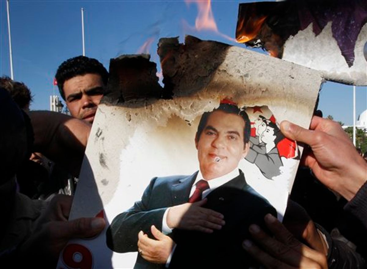 FILE - In this Monday, Jan. 24, 2011 picture, protestors burn a photo of former Tunisian President Zine El Abidine Ben Ali during a demonstration against holdovers from Ben Ali's regime in the interim government in Tunis, Tunisia. Tunisia's former autocratic leader whose downfall triggered uprisings in the Arab world has condemned his upcoming trial in absentia in Tunis as a "shameful masquerade." Ben Ali - in exile in Saudi Arabia - also said Sunday, June 19, 2011 in a statement from his French lawyer that he didn't flBeee Tunisia but left to avoid "fratricidal and deadly confrontations." (AP Photo/Christophe Ena, File) (AP)