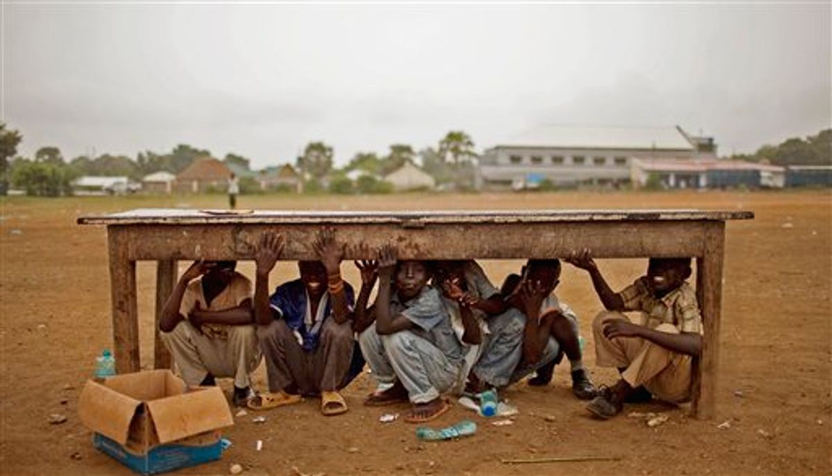 Southern Sudanese boys take shelter from afternoon rains that disrupted rehearsal for independence day celebrations in the capital city of Juba on Monday, July 4, 2011.  (AP/Pete Muller)