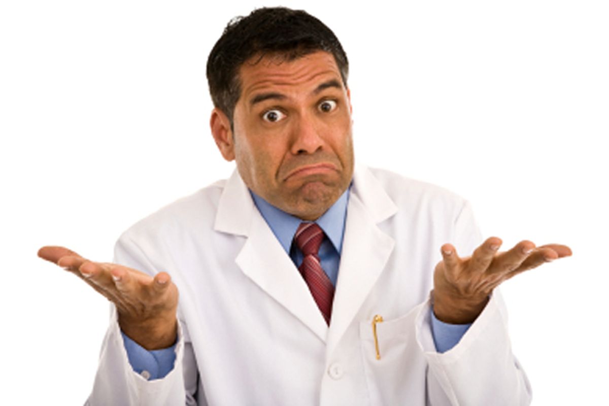 Mid adult Hispanic male wearing lab coat shrugging, isolated on white background (Derek Latta)