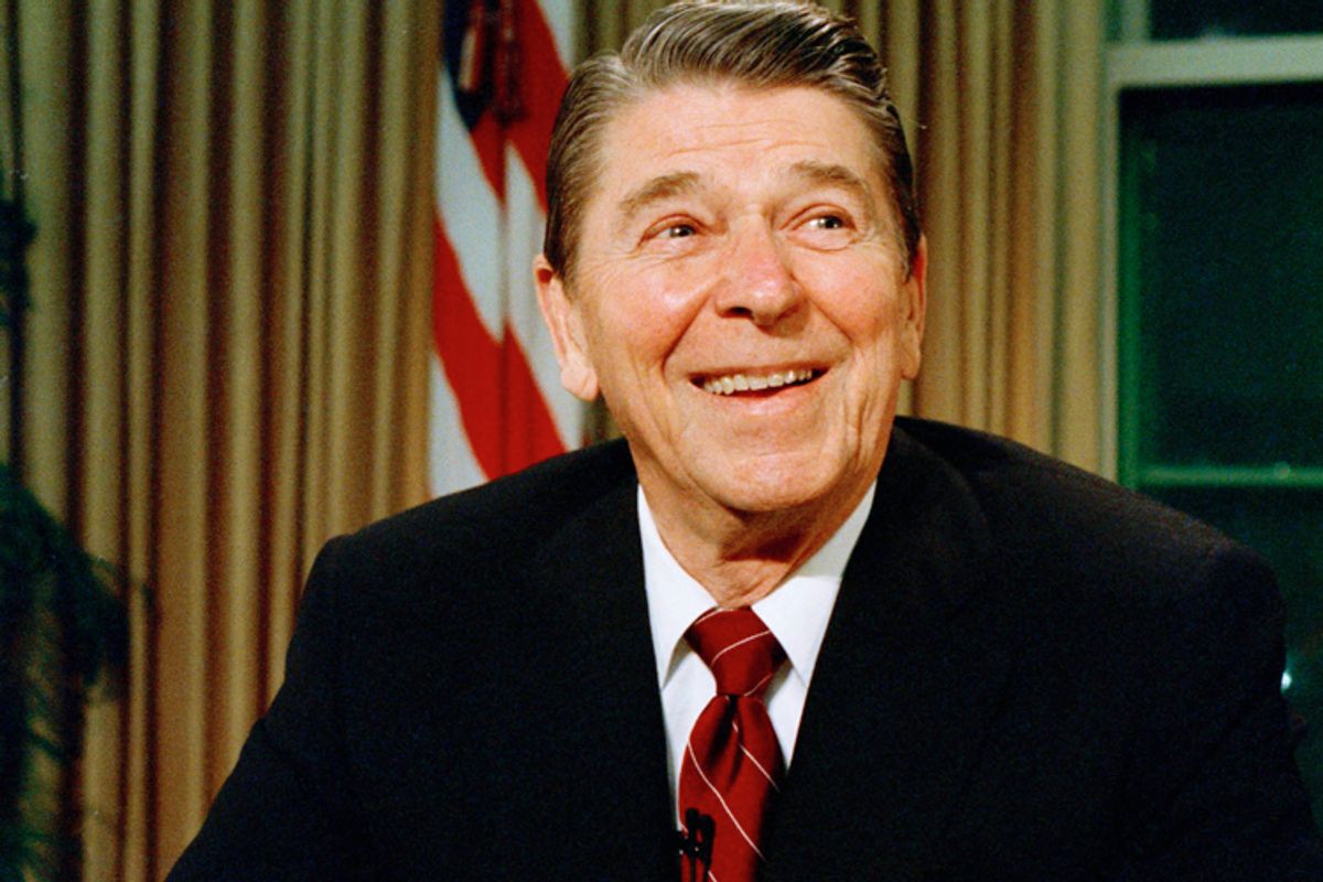 President Ronald Reagan smiles as he poses for photographers after delivering a speech on television, in this Dec. 11, 1987 file photo.
