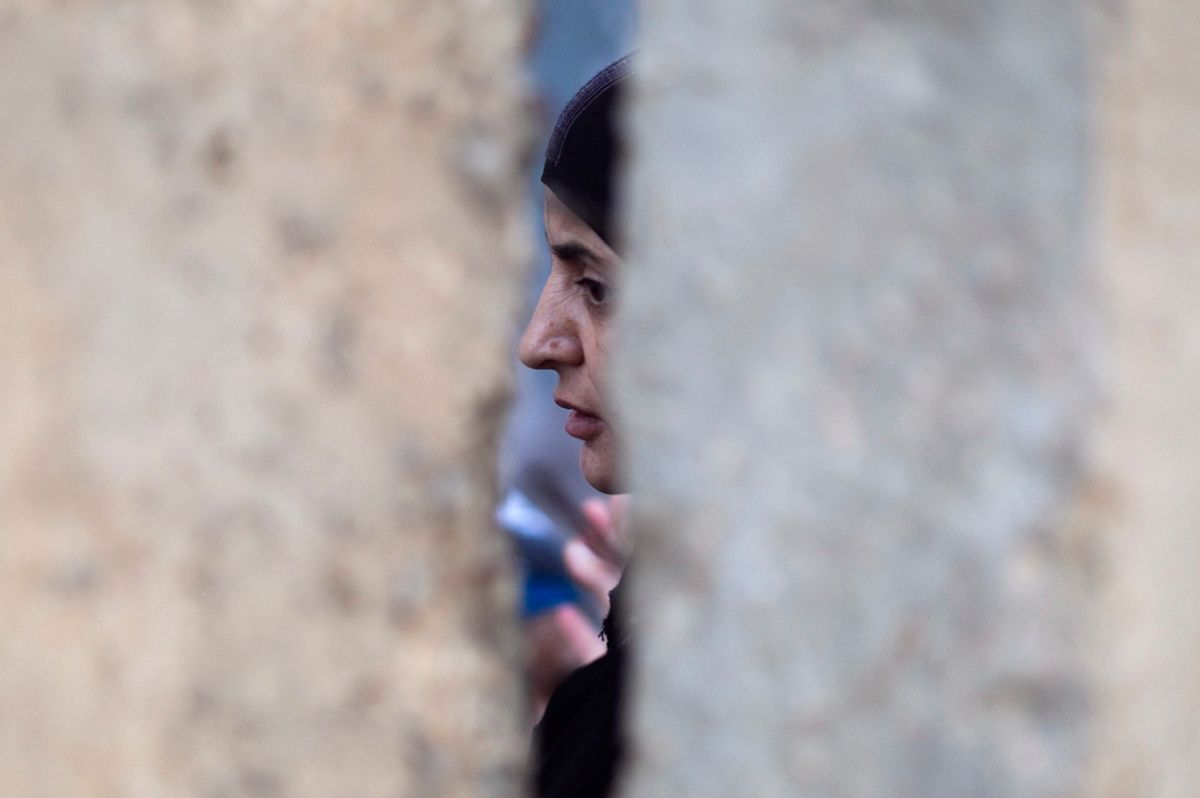 A Palestinian woman waits behind a wall after she was refused entry to cross into Jerusalem from Israel's Qalandiya checkpoint outside the West Bank city of Ramallah, during the third Friday of the holy month of Ramadan August 19, 2011. REUTERS/Darren Whiteside (WEST BANK - Tags: RELIGION POLITICS) (Â© Darren Whiteside / Reuters)