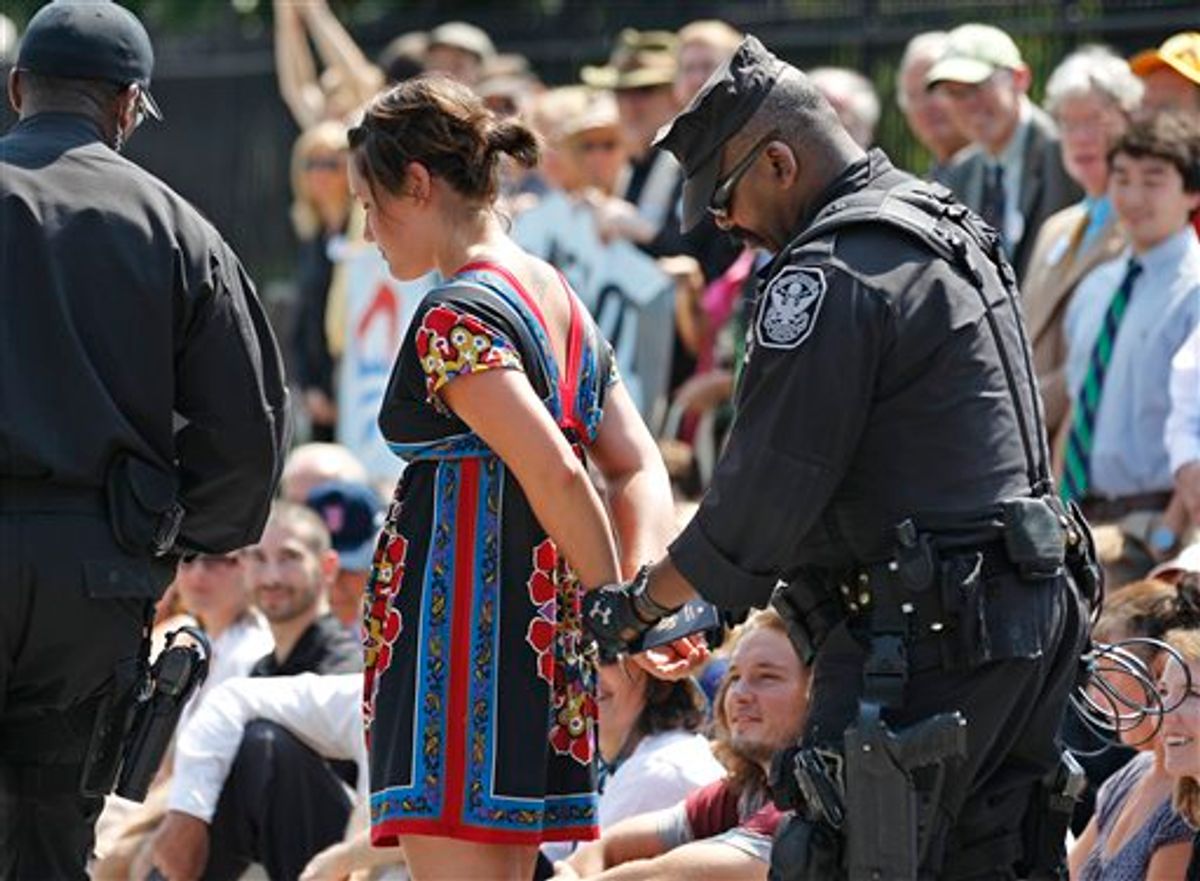 A U.S. Park Police officer handcuffs and arrests a protestor over a proposed pipeline to bring tar sands oil to the U.S. from Canada, in front of the White House in Washington, Saturday, Aug. 20, 2011.    (AP Photo/Manuel Balce Ceneta)  (AP)