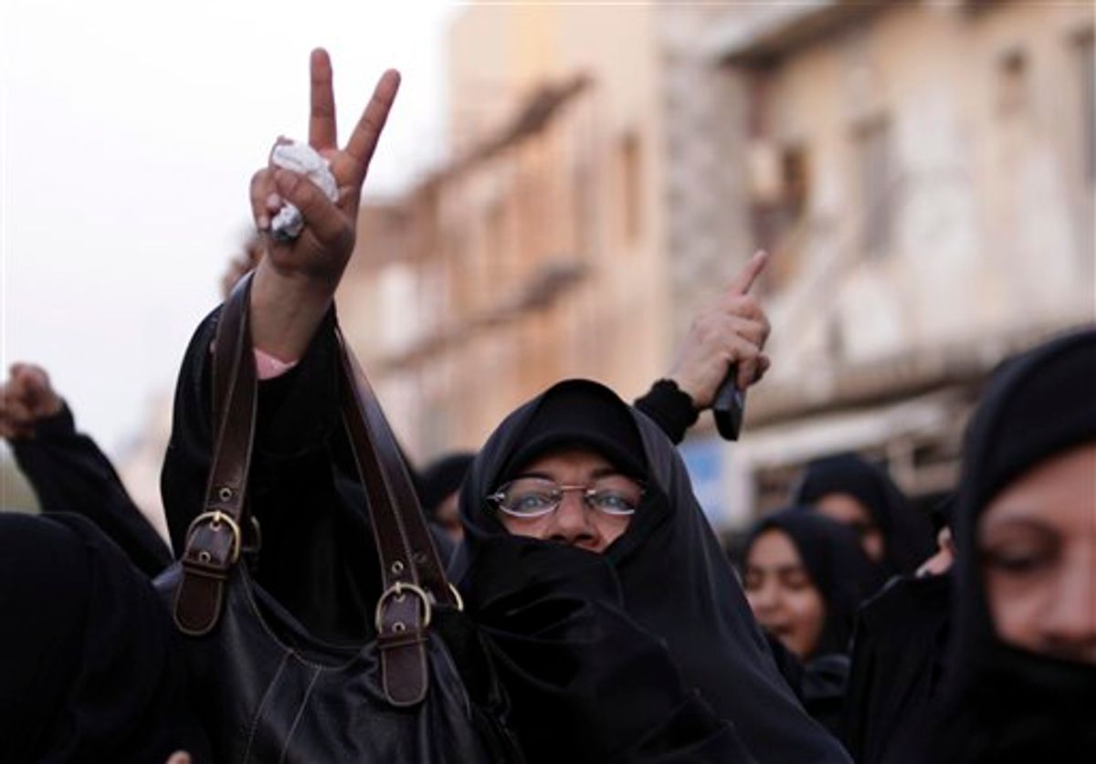 A Shiite Bahraini woman gestures as others shout anti-government slogans outside a public forum Saturday, July 23, 2011,  outside a religious community center in Sanabis, Bahrain, denouncing the alleged destruction and vandalizing of Shiite mosques, community centers and cemeteries during a government crackdown on a largely Shiite spring uprising.  Clerics who spoke during the meeting, blamed Saudi Arabia for targeting religious sites, because they allegedly distrust their own Shia minority and sent forces to help quell the Bahrain uprising. (AP Photo/Hasan Jamali) (AP)