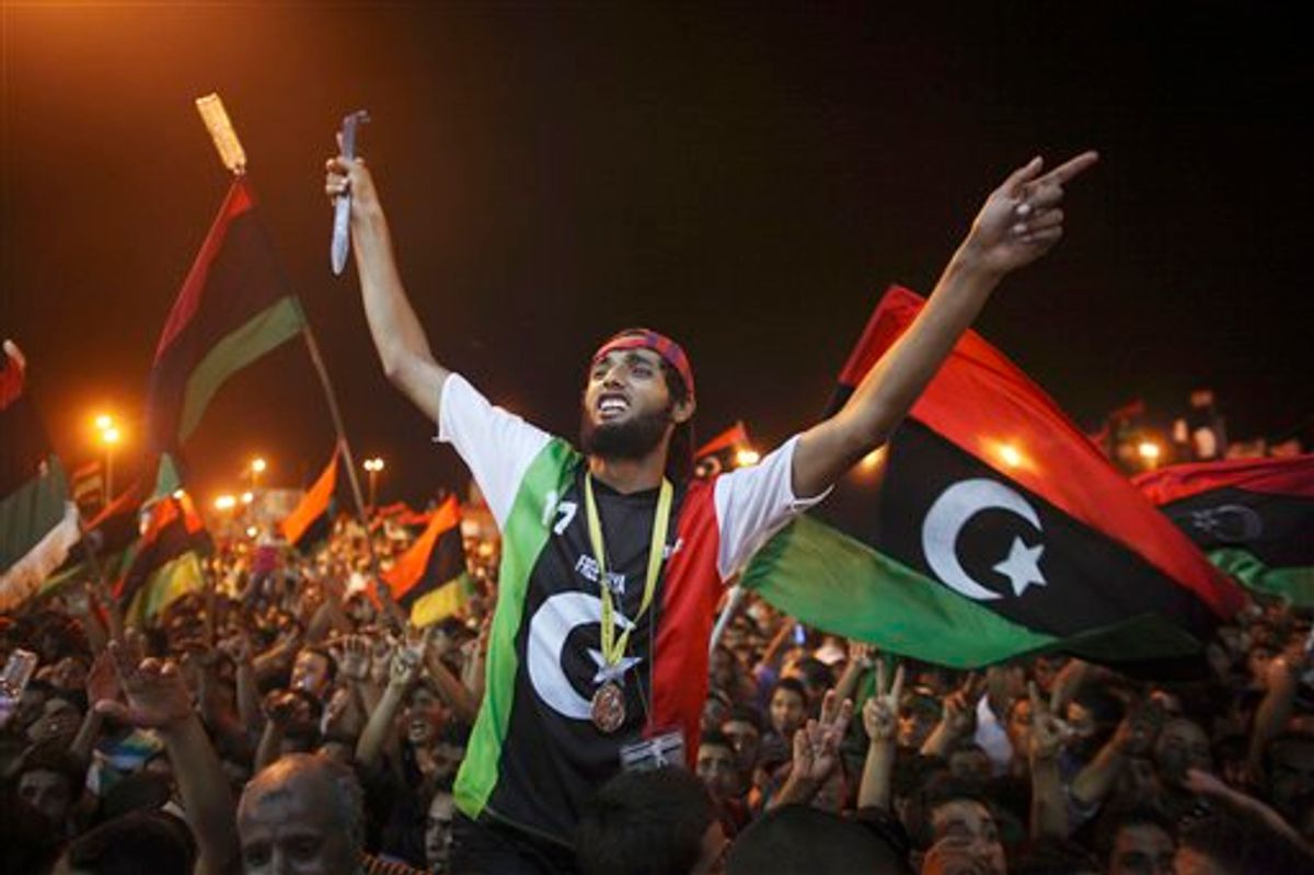 People celebrate the capture in Tripoli of Moammar Gadhafi's son and one-time heir apparent, Seif al-Islam, at the rebel-held town of Benghazi, Libya, early Monday, Aug. 22, 2011. Libyan rebels raced into Tripoli in a lightning advance Sunday that met little resistance as Moammar Gadhafi's defenders melted away and his 40-year rule appeared to rapidly crumble. The euphoric fighters celebrated with residents of the capital in the city's main square, the symbolic heart of the regime. (AP Photo/Alexandre Meneghini) (AP)