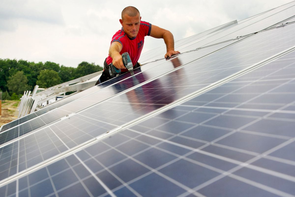 A worker fixes solar modules at a solar park in Spremberg, Germany