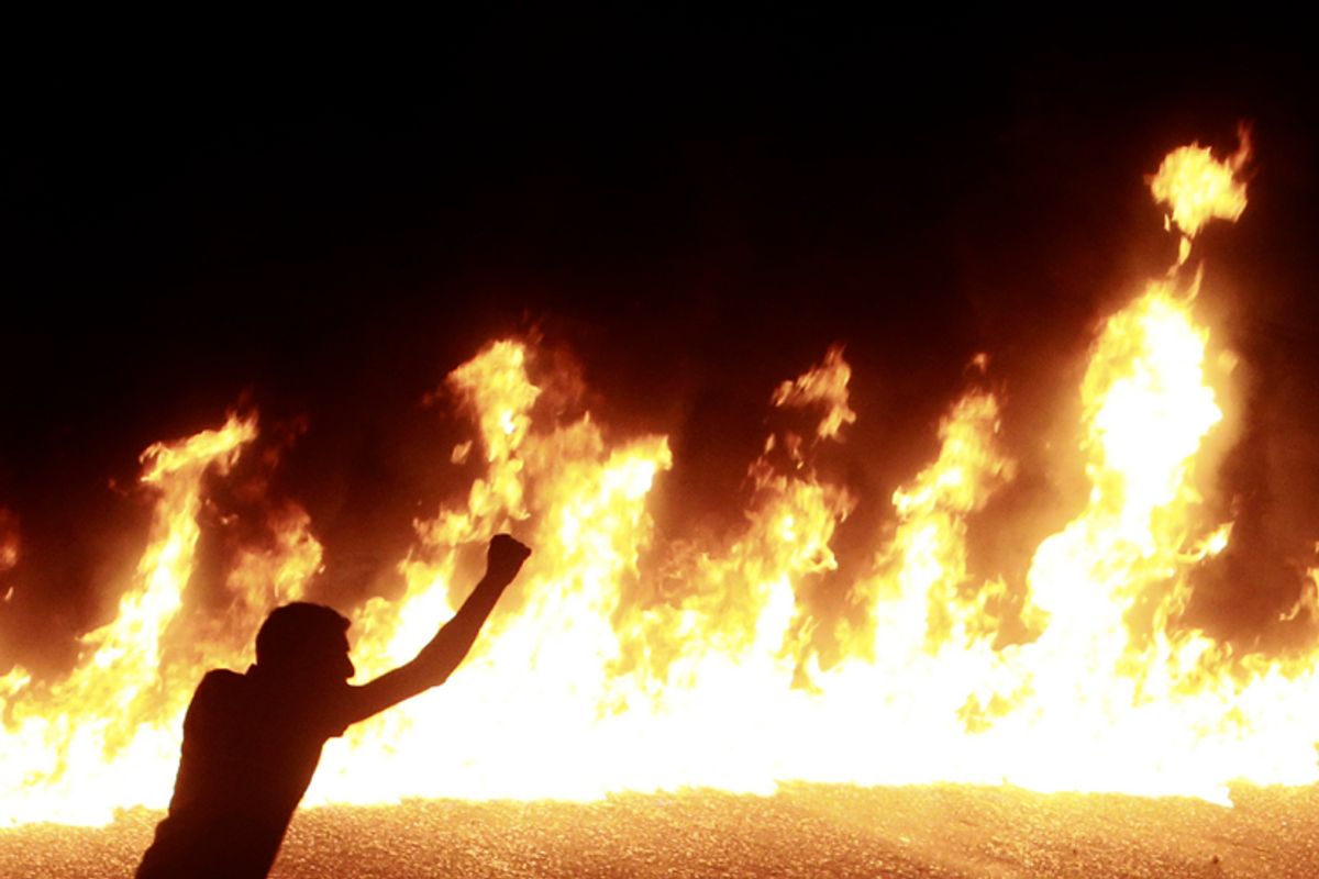 A protester stands near a line of fire during a demonstration in Cairo October 9, 2011.   (Amr Dalsh / Reuters)