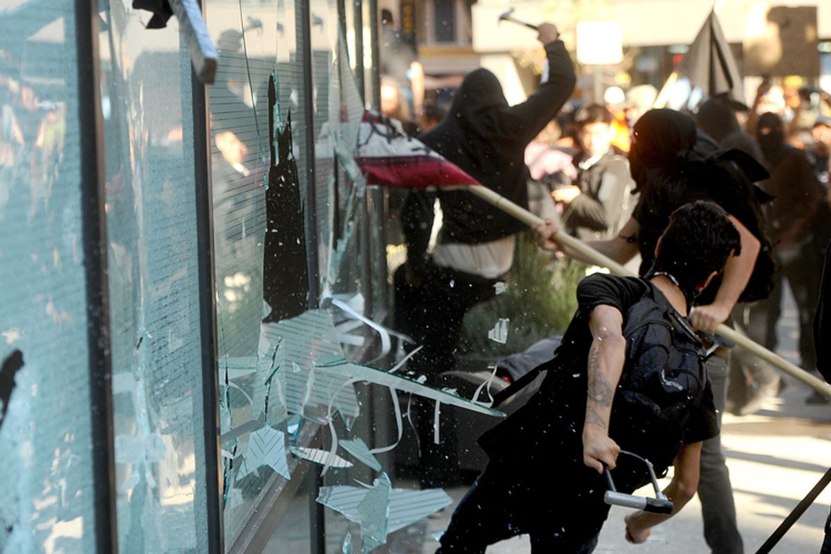 A small group of Occupy Oakland protesters smash windows at a Wells Fargo bank branch on Wednesday, Nov. 2, 2011, in Oakland, Calif.    (Noah Berger/AP)
