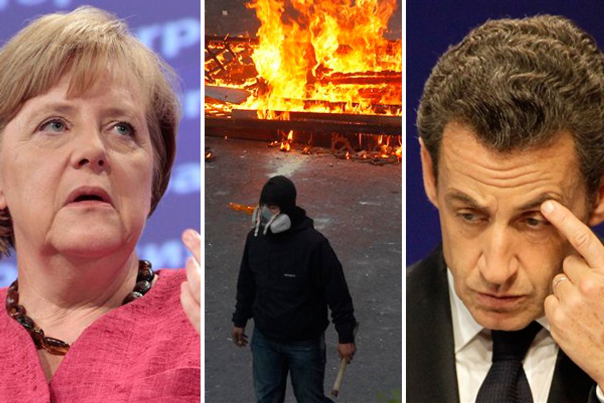 German Chancellor Angela Merkel and French President Nicolas Sarkozy. Center: A protester passes by a burning barricade during clashes in Athens.          (AP)