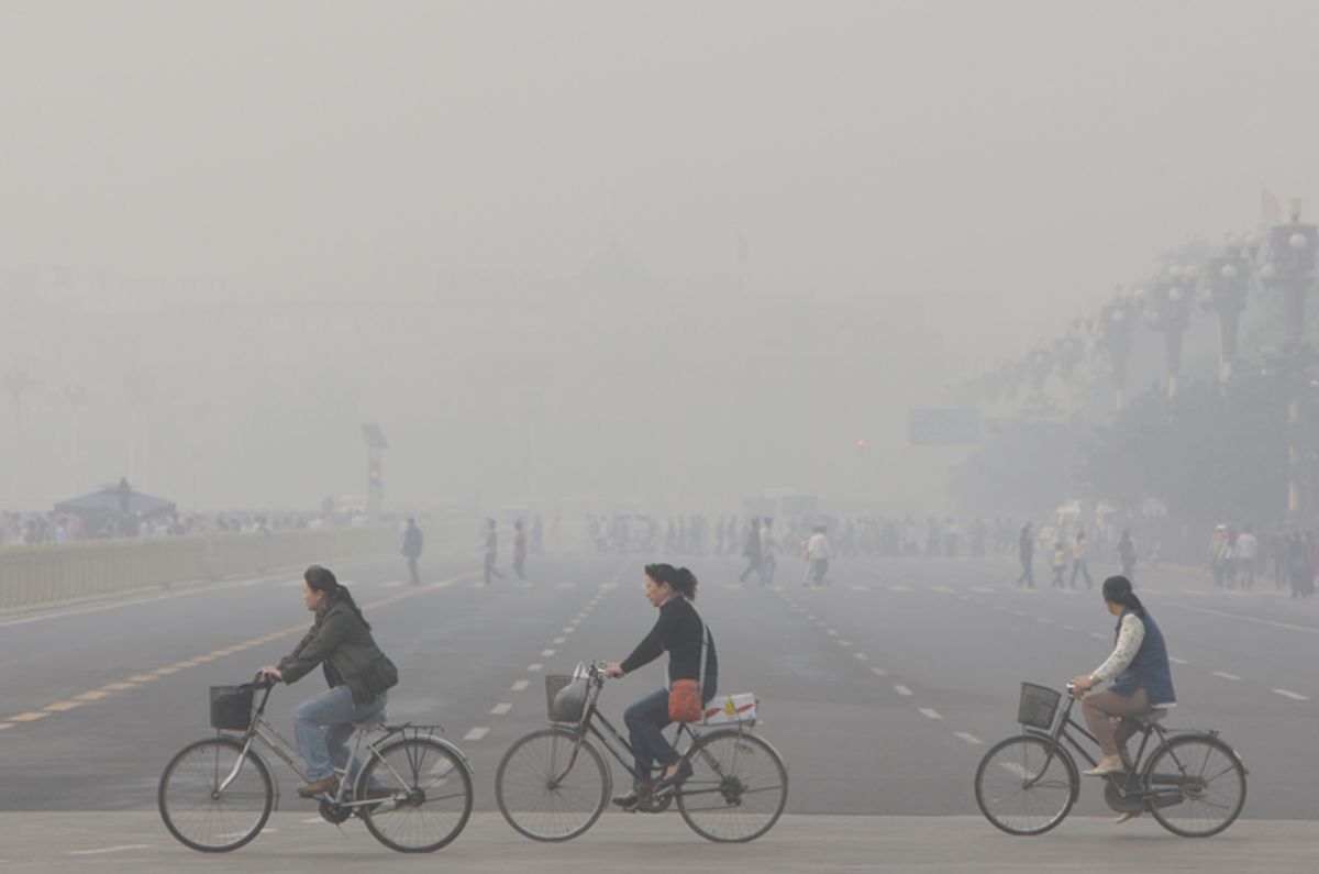 Chinese women cycle through smog and pollution over Beijing's Tiananmen Square    (AP)