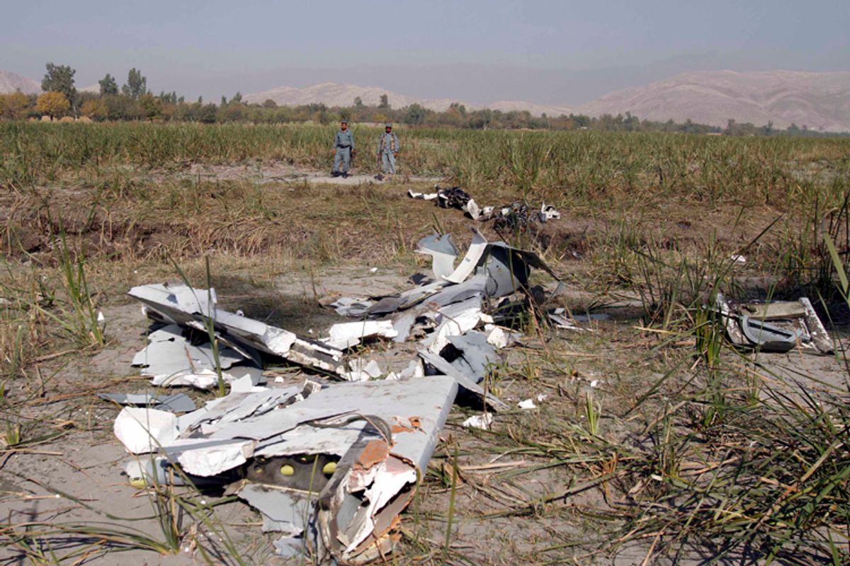 Afghan policemen stand guard near the remains of a US Predator, an unmanned drone, after it crashed on the outskirts of Jalalabad, east of Kabul, Afghanistan, Wednesday, Nov 2, 2010.        (AP/Rahmat Gul)