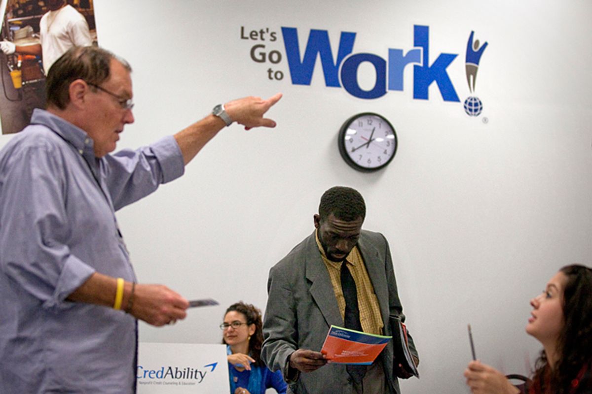 In this Oct. 4, 2011 photo, Snotti St. Cyr, center, looks over a brochure while attending a job fair at a Goodwiill store in Atlanta. The number of people who applied for unemployment benefits rose slightly last week, a sign that the job market remains weak. (AP Photo/David Goldman)  (David Goldman)