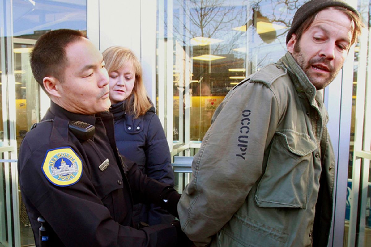 A protester is arrested for blocking the entrance to Republican presidential candidate Mitt Romney's local campaign office during an Occupy The Caucus demonstration in Des Moines, Iowa.  (AP/J. David Ake)