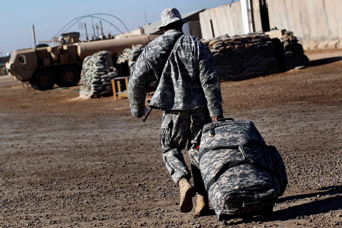 U.S. Army Sgt. Omar Sprott, from Brooklyn, New York, of the 115th Brigade Support Battalion carries his luggage in preparation for leaving Camp Kalsu near Hillla, Iraq December 6, 2011.       (© Shannon Stapleton / Reuters)