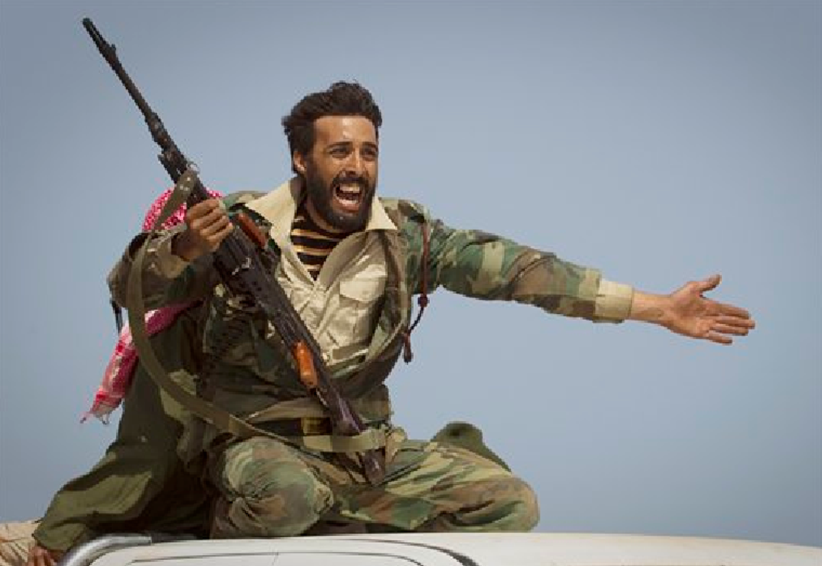  In this March 29, 2011 file photo, a Libyan rebel urges people to leave, as shelling from Gadhafi's forces started landing on the frontline outside of Bin Jawaad, 150 km east of Sirte, central Libya. (AP Photo/Anja Niedringhaus, File)     