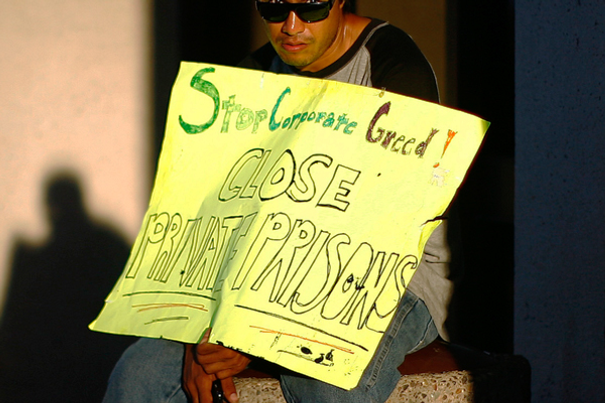 A protester displays a placard reading "Stop corporate greed. Close private prisons" as he takes part in an Occupy Phoenix demonstration on Oct. 17, 2011                (Reuters/Eric Thayer)