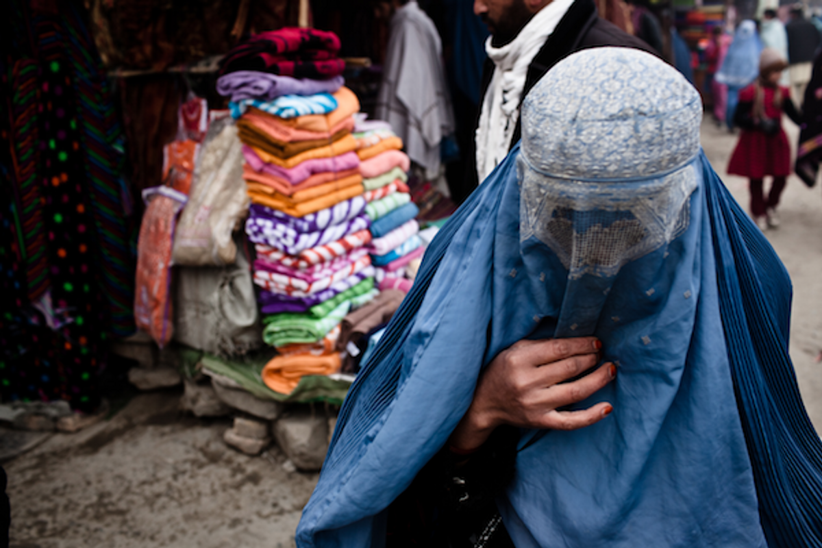  A woman in a burka walks through a market in a heavily populated Pashtun neighborhood on the outskirts of Kabul, Afghanistan, Dec. 19, 2011   (Erin Trieb/VII/GlobalPost)