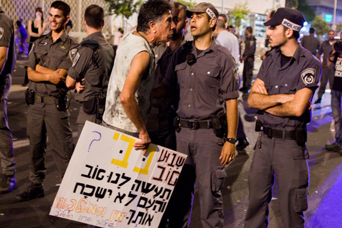  In this Aug. 7, 2011, photo, Israeli police officers line up in front of a protester at the end of a rally in central Tel Aviv, Israel.  