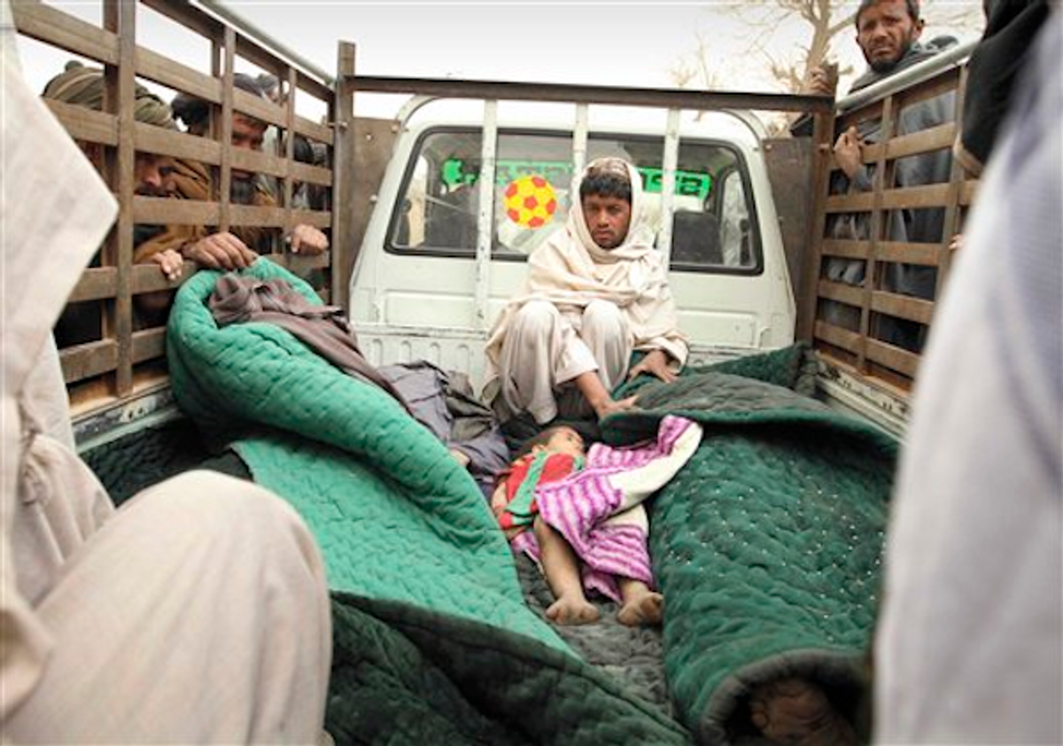 A man sits in the back of a truck with the bodies of several men and a child allegedly killed by a U.S. service member in Panjwai, Kandahar province south of Kabul, Afghanistan, Sunday, March 11, 2012 (AP Photo/Allauddin Khan)