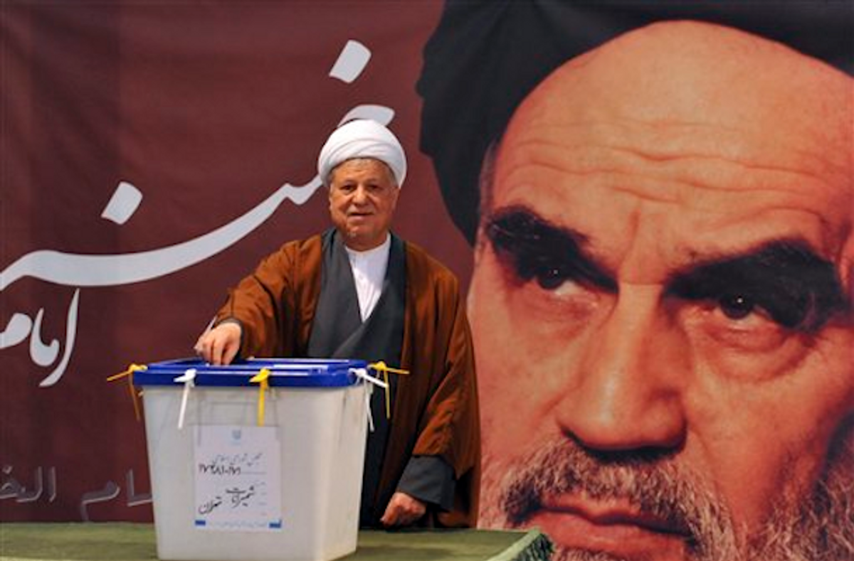  In front of a portrait of late Iranian leader Ayatollah Khomeini, former President Akbar Hashemi Rafsanjani casts his ballot for the parliamentary elections at a polling station in Tehran, Iran, Friday, March 2, 2012    (AP Photo/ISNA, Ruhollah Vahdati)