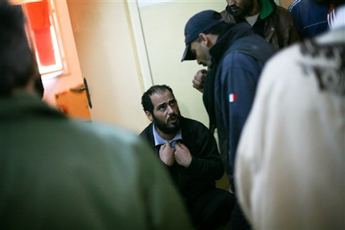  In this Saturday, Feb. 24, 2012 photo, a fighter loyal to the former Libyan dictator Moammar Gadhafi argues with the prison guards in Gherian, Libya    (AP Photo/Manu Brabo)